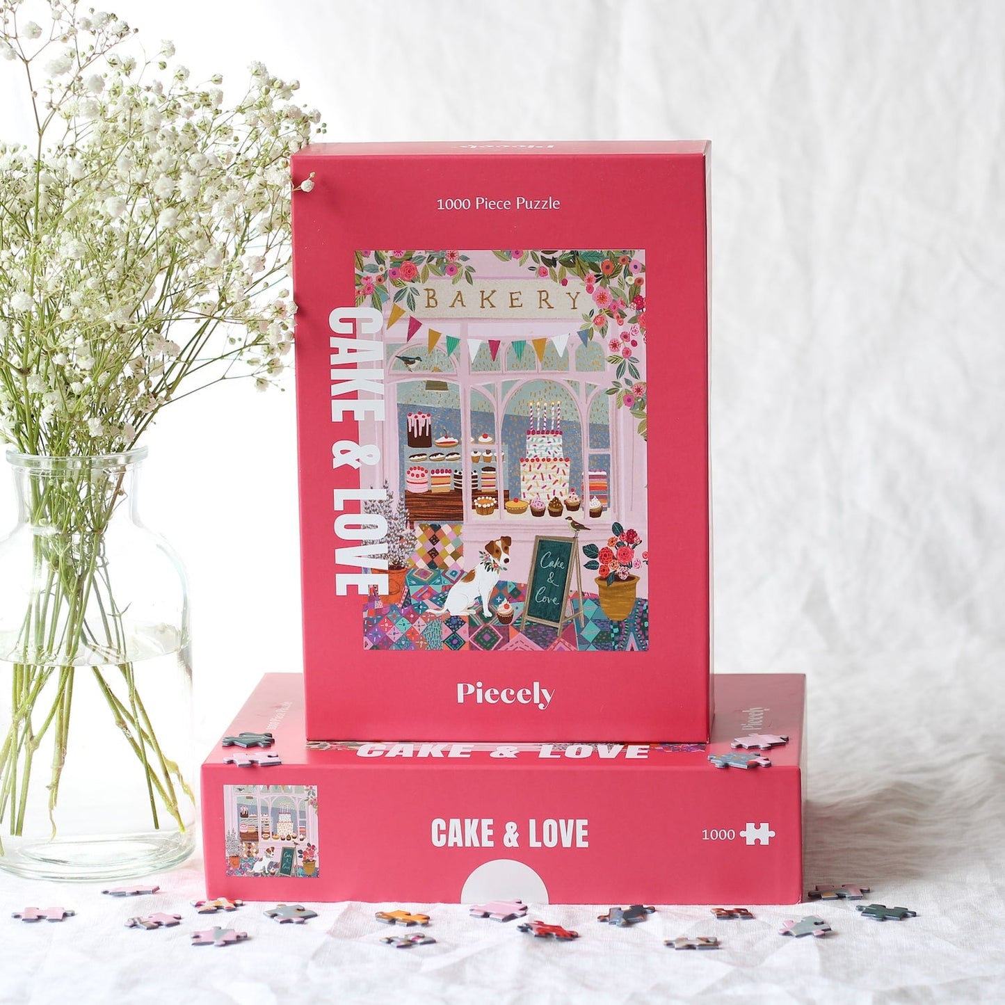 Außergewöhnliches 1000-Teile-Puzzle für Erwachsene, das eine rosa Bäckerei mit Torten, Kuchen und Cupcakes im Schaufenster und einen kleinen Hund für der Tür zeigt.