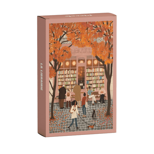 99-Teile-Mini-Puzzle „La Librairie“ von Piecely – Illustration einer herbstlichen Straßenszene vor einer Pariser Buchhandlung, auf rosafarbener Verpackung.