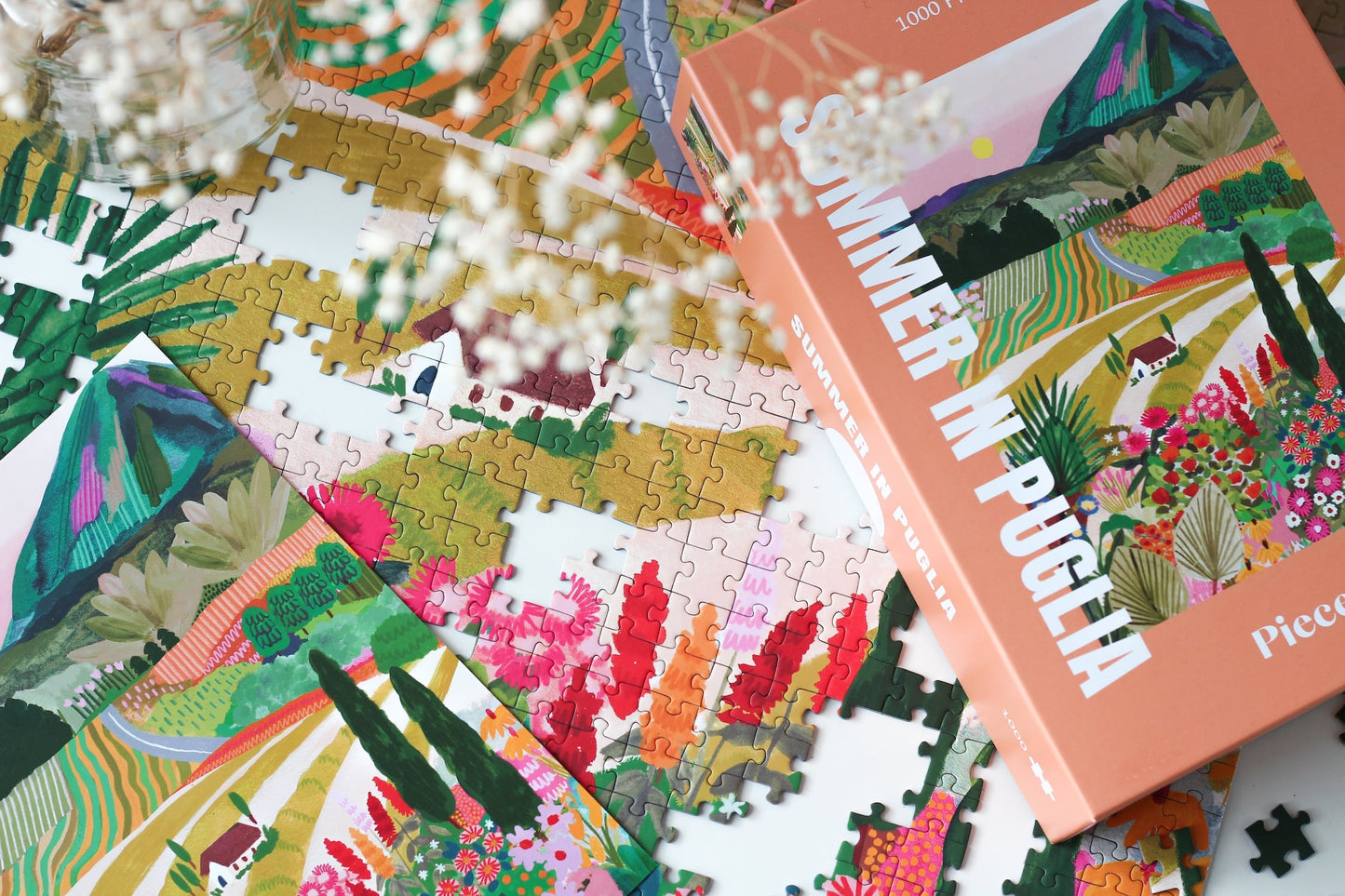 Außergewöhnliches 1000-Teile-Puzzle für Erwachsene, das die sommerliche Landschaft Apuliens in Italien zeigt. Zu sehen sind blühende Felder, Ein Berg und ein kleines Haus.