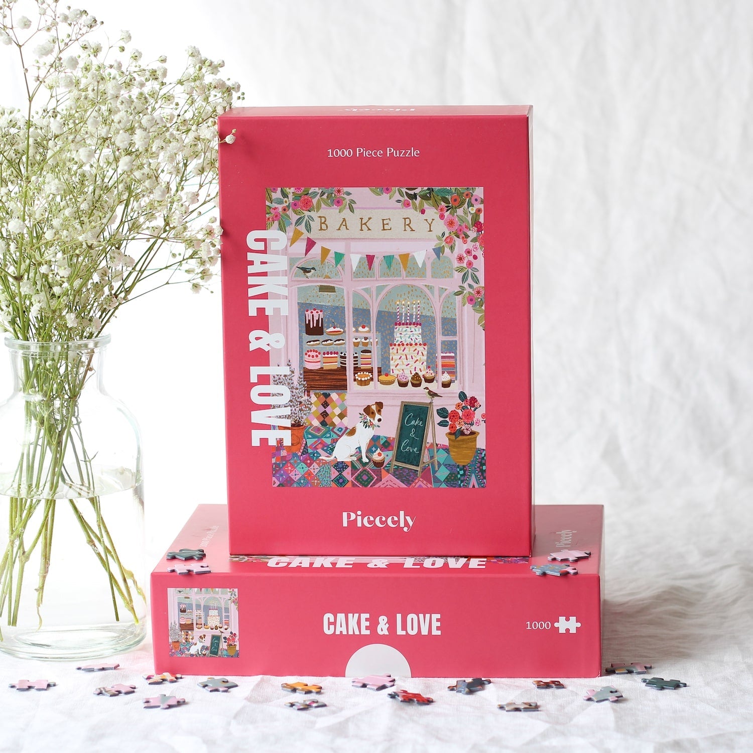 Außergewöhnliches 1000-Teile-Puzzle für Erwachsene, das eine rosa Bäckerei mit Torten, Kuchen und Cupcakes im Schaufenster und einen kleinen Hund für der Tür zeigt.