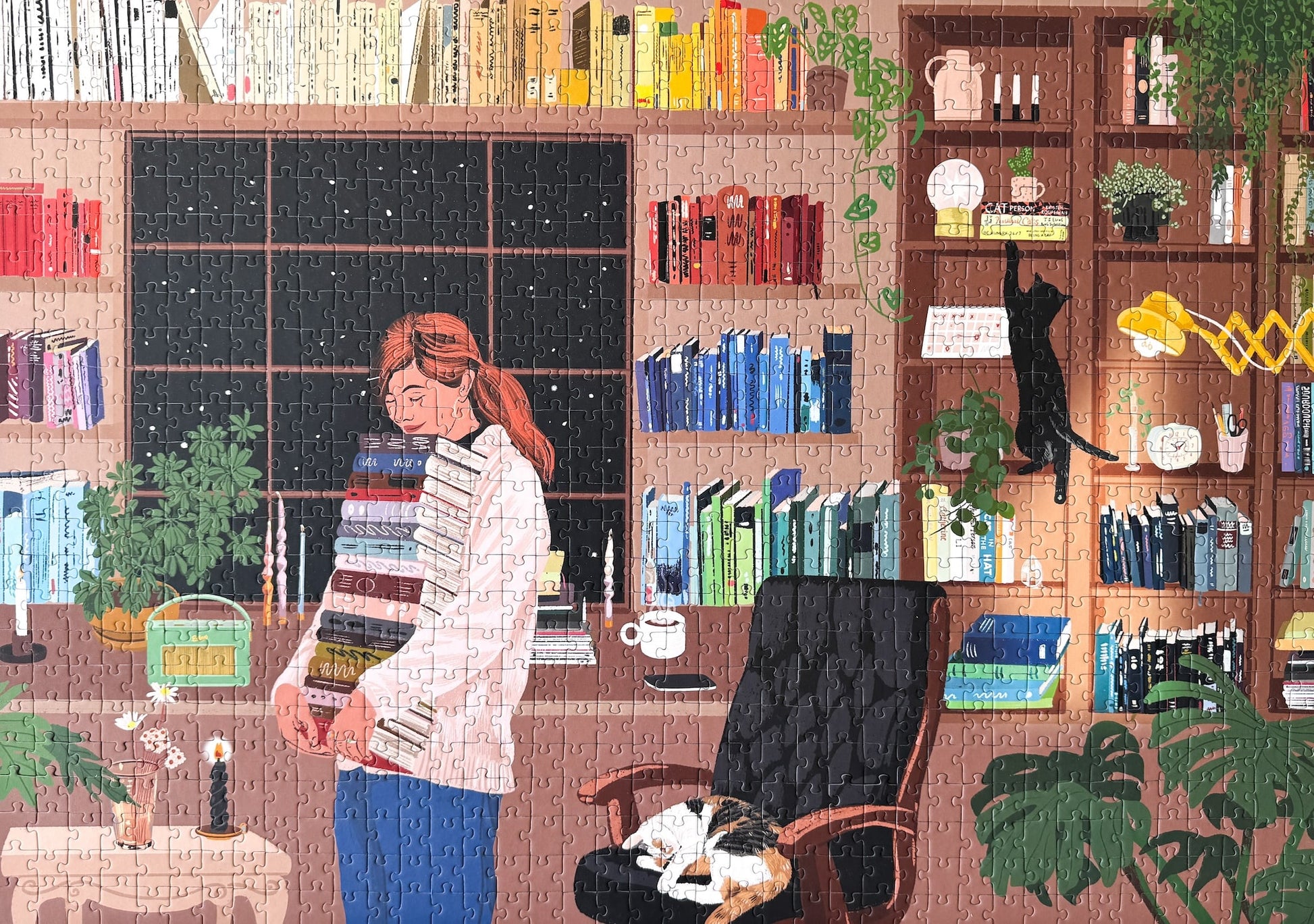Nachhaltiges 1000-Teile-Puzzle, das eine Frau mit einem Stapel Bücher in der Hand zeigt. Im Hintergrund ist ein prall gefülltes Bücherregal und zwei süße Katzen.