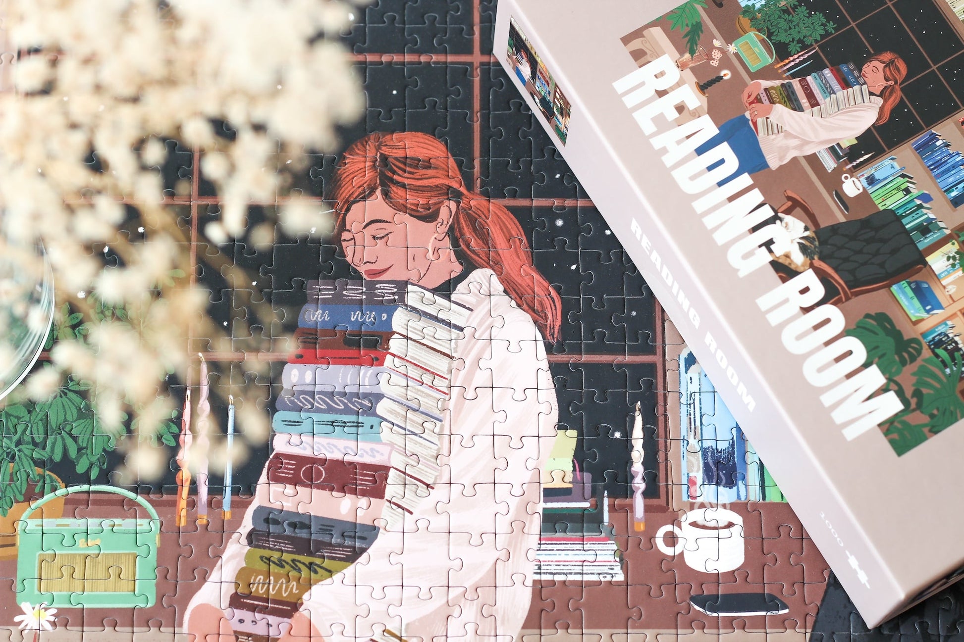Nachhaltiges 1000-Teile-Puzzle, das eine Frau mit einem Stapel Bücher in der Hand zeigt. Im Hintergrund ist ein prall gefülltes Bücherregal und zwei süße Katzen.