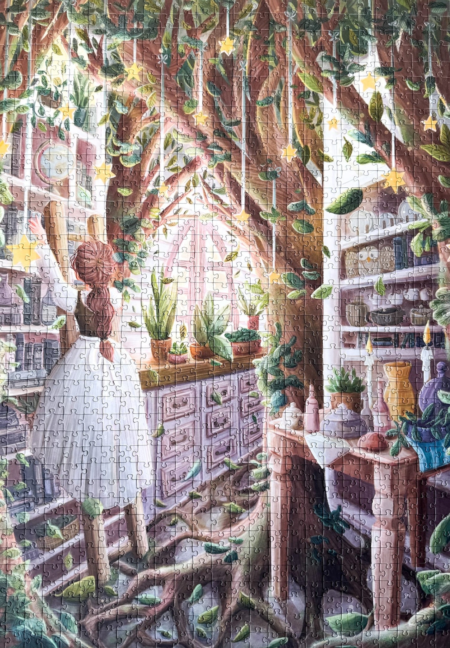 1000-teiliges Puzzle für Erwachsene, das eine Frau auf einer Leiter in einer verwunschenen Küche zeigt. Mitten in der Küche wächst ein Baum und die Regale sind gefüllt mit Büchern, Porzellan und Pflanzen.