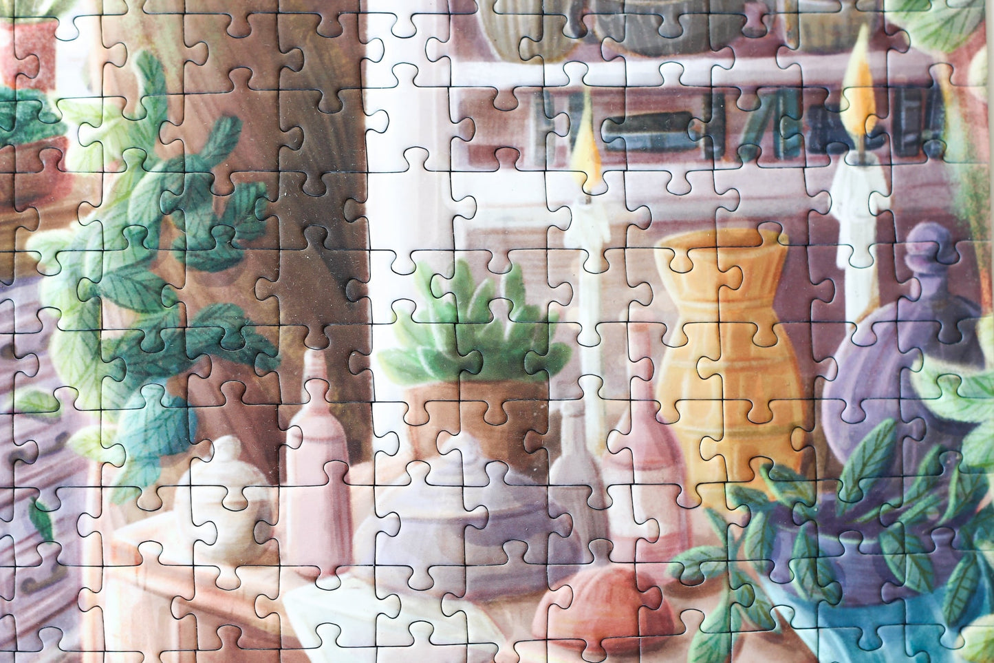 1000-teiliges Puzzle für Erwachsene, das eine Frau auf einer Leiter in einer verwunschenen Küche zeigt. Mitten in der Küche wächst ein Baum und die Regale sind gefüllt mit Büchern, Porzellan und Pflanzen.